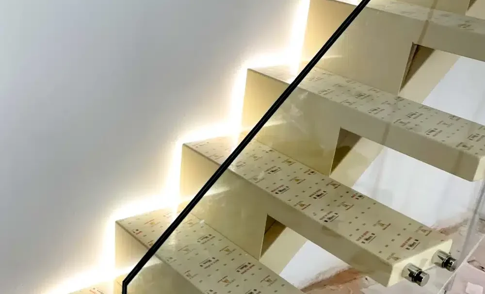 Detalle escalera semivolada con peldaños volados con luz y cristal